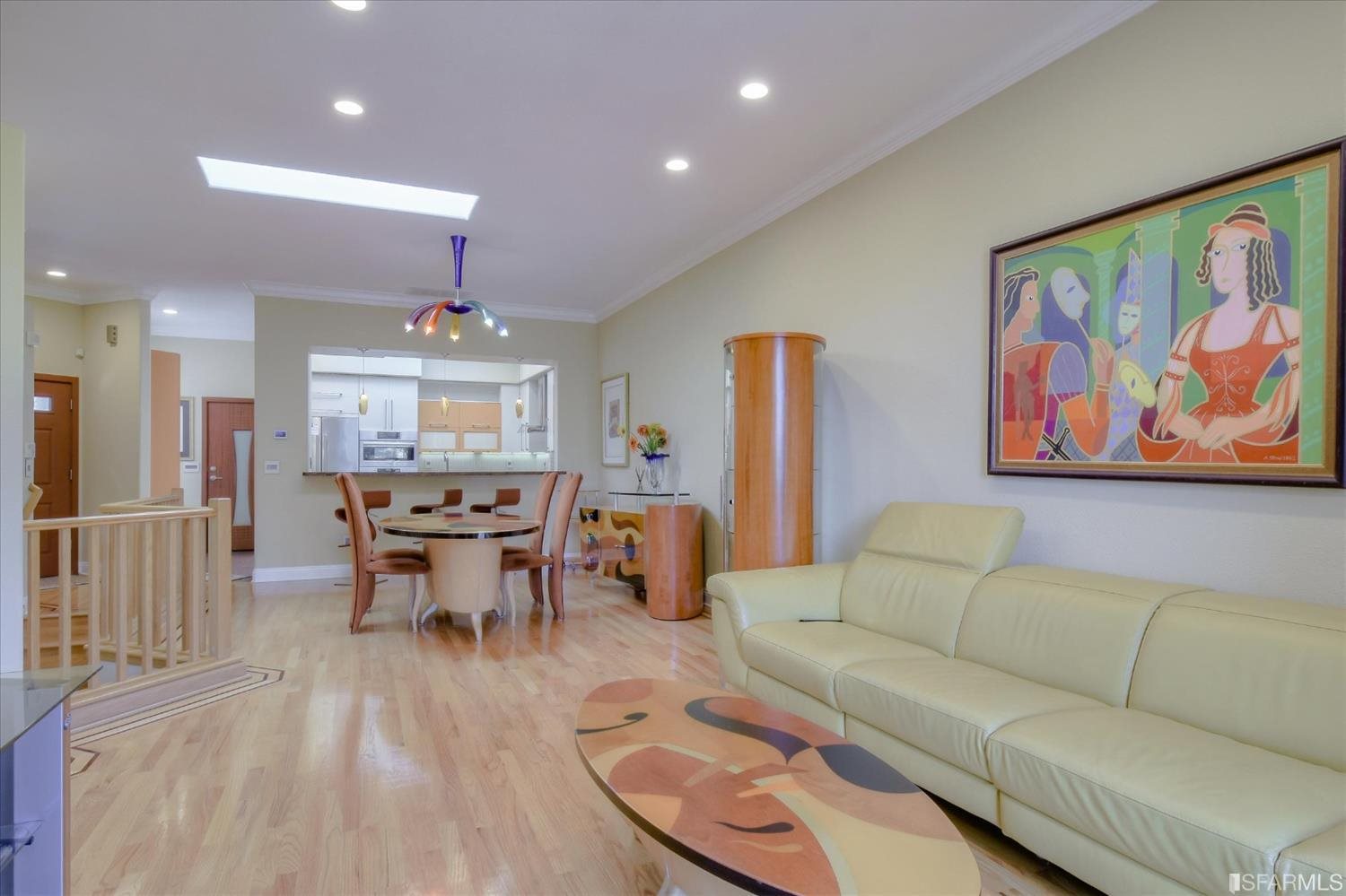 a living room with furniture a refrigerator and kitchen view