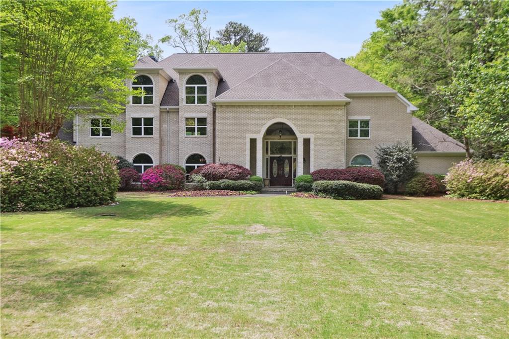 a front view of house with yard and trees