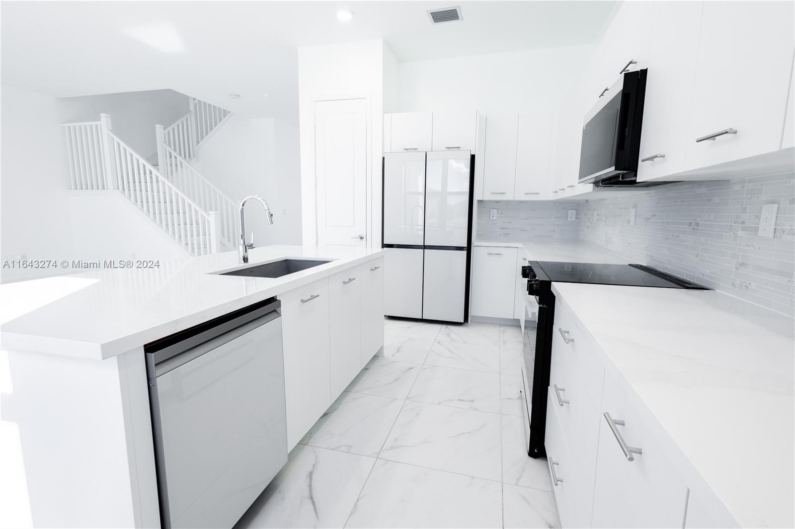 a kitchen with a sink and a refrigerator