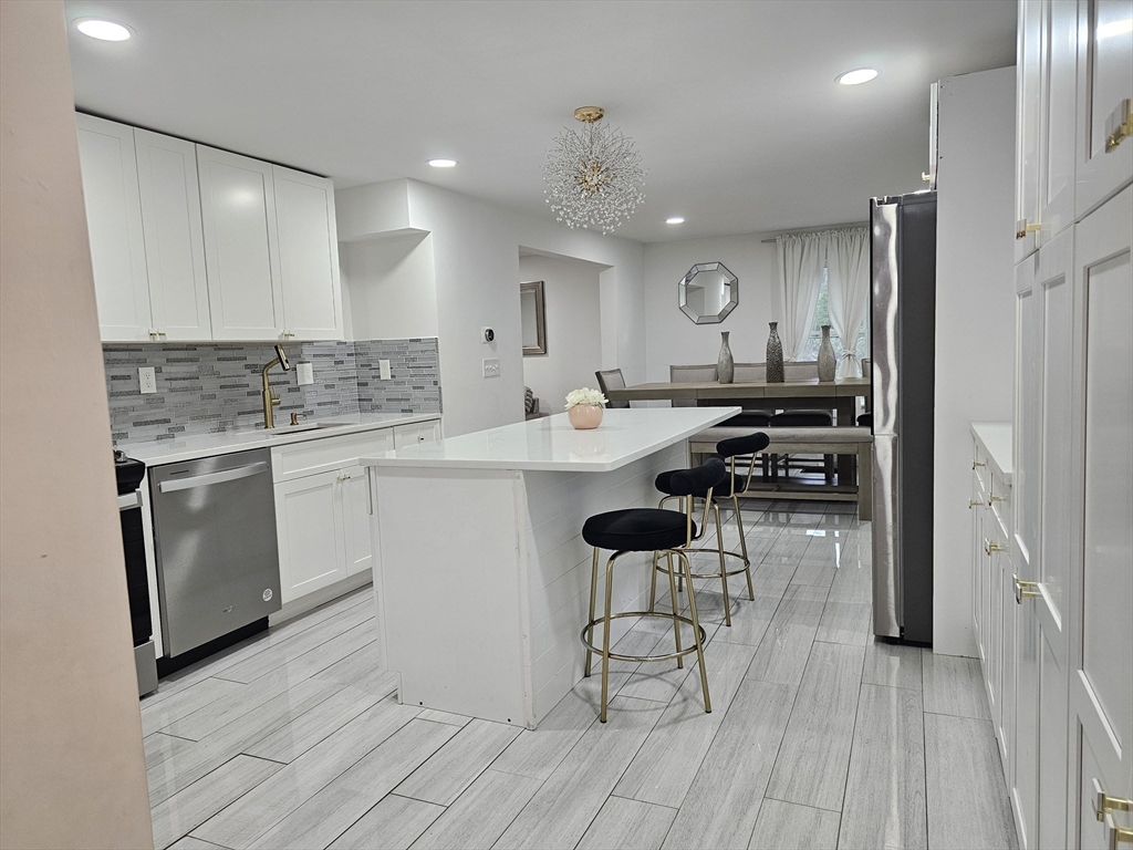 a kitchen with a sink cabinets and wooden floor