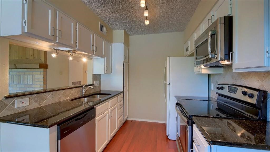 a kitchen with granite countertop a stove and a sink