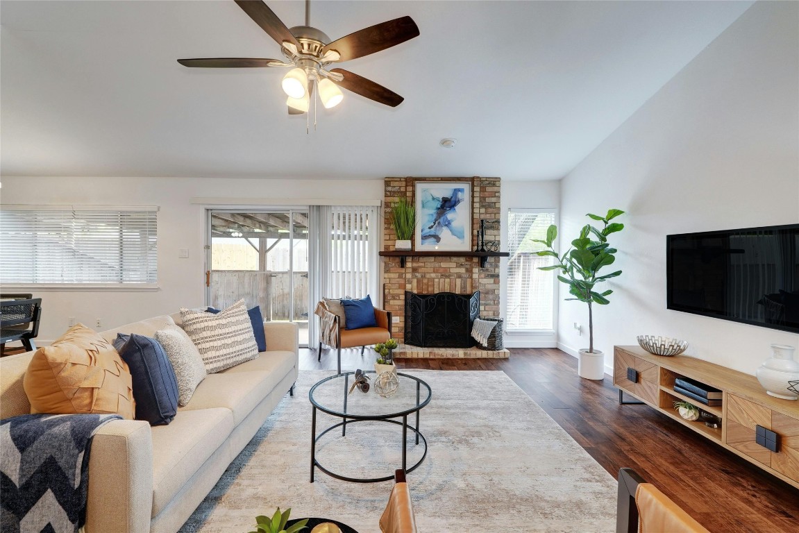 a living room with furniture a flat screen tv and a fireplace