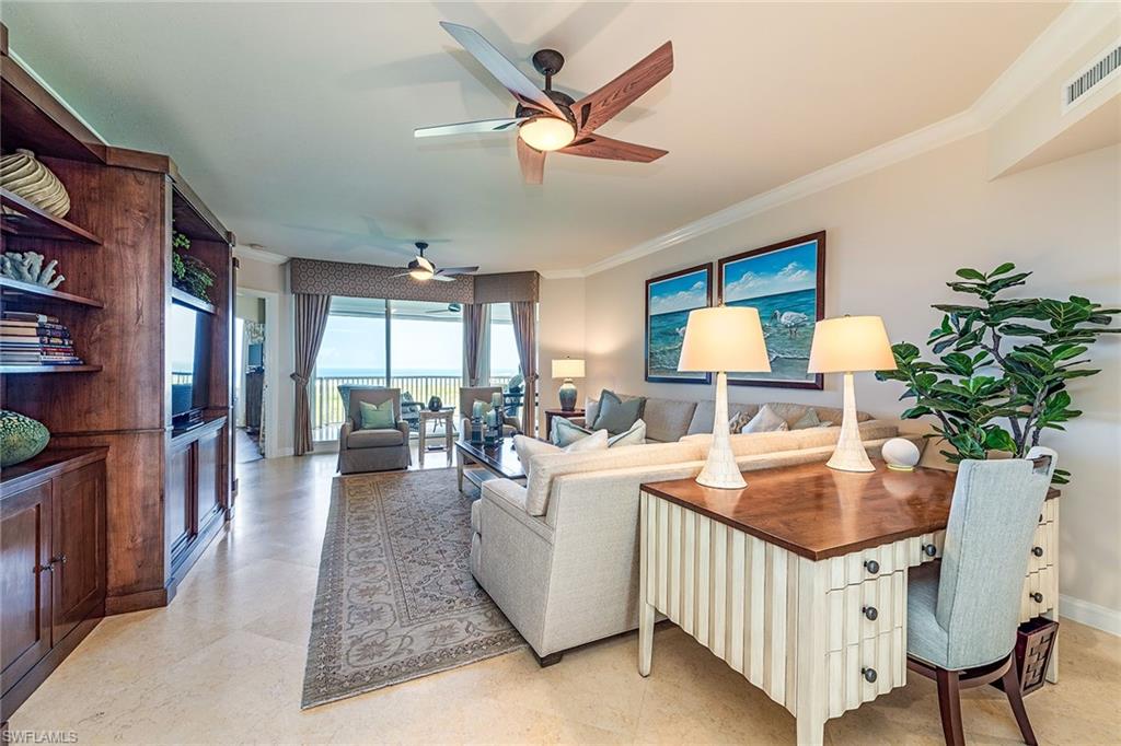 a living room with furniture a chandelier and a dining table