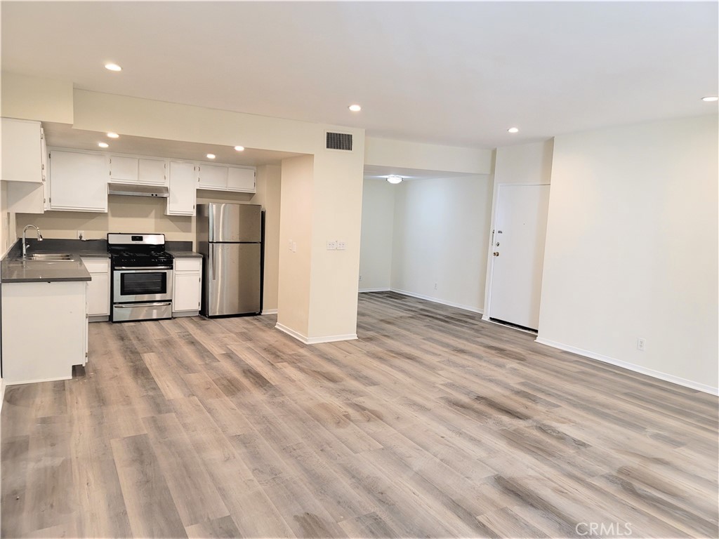 a view of kitchen with stainless steel appliances refrigerator stove microwave and cabinets