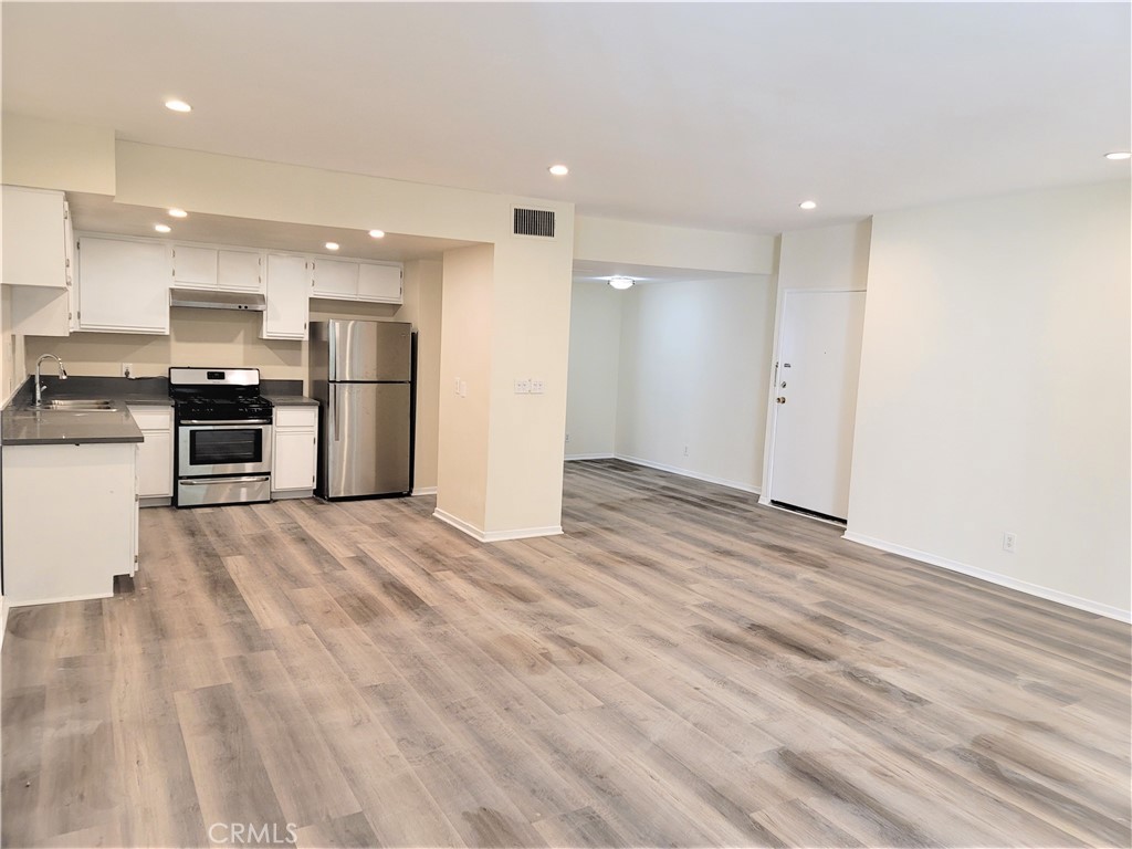 a view of kitchen view wooden floor stainless steel appliances and cabinets