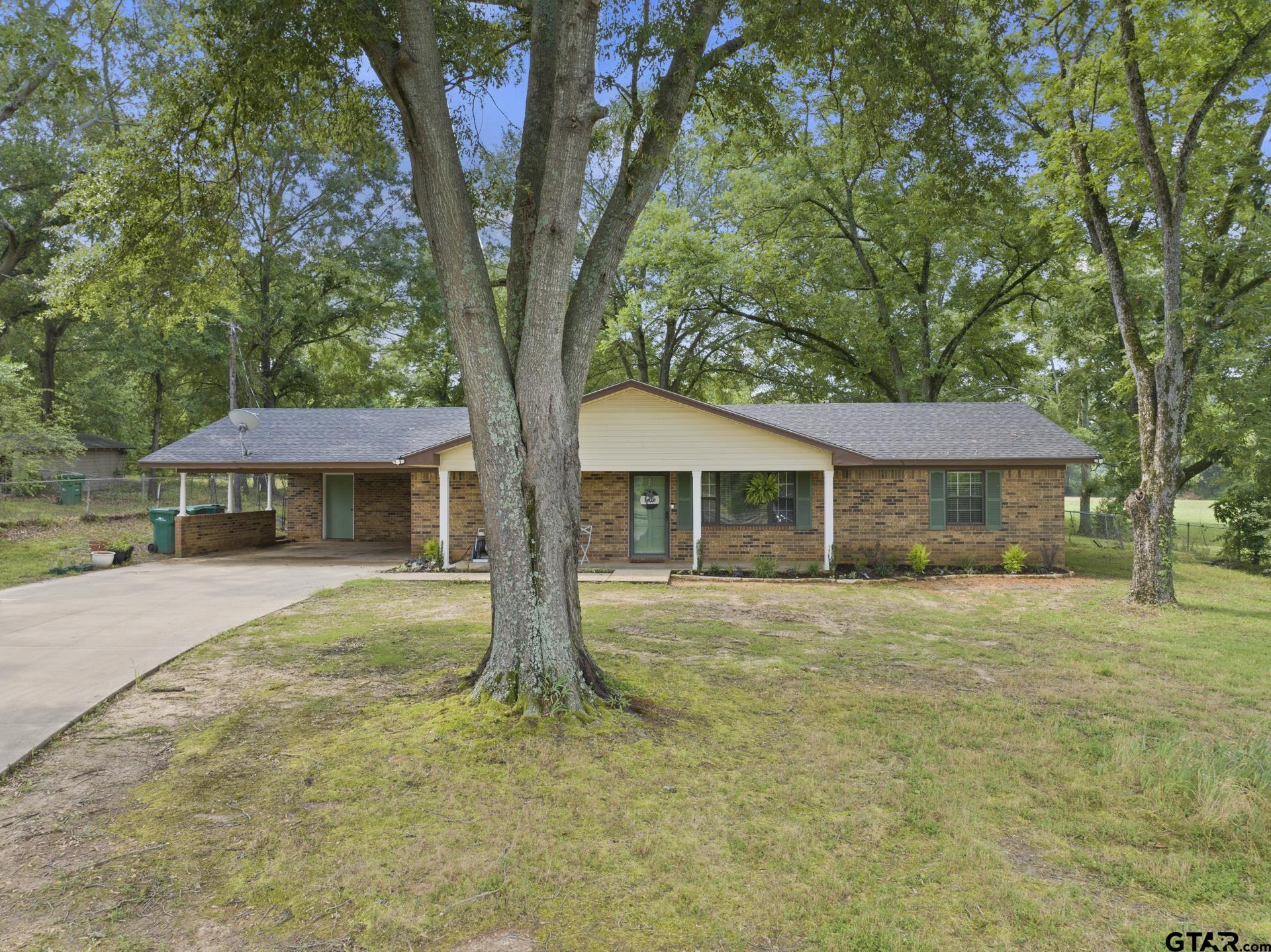 a front view of a house with yard and trees