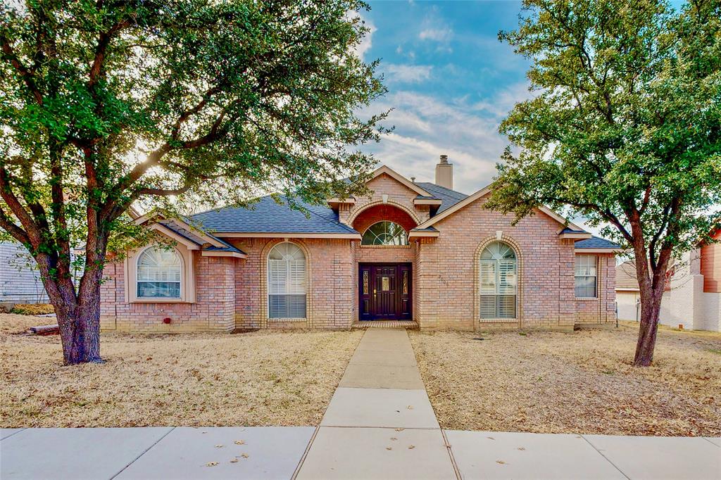 a front view of a house with a tree