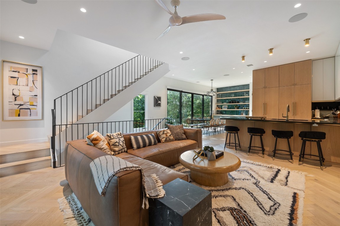 a living room with furniture and a dining table with wooden floor