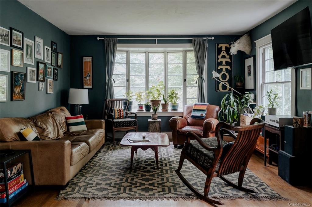 Living room featuring hardwood floors & oversized windows