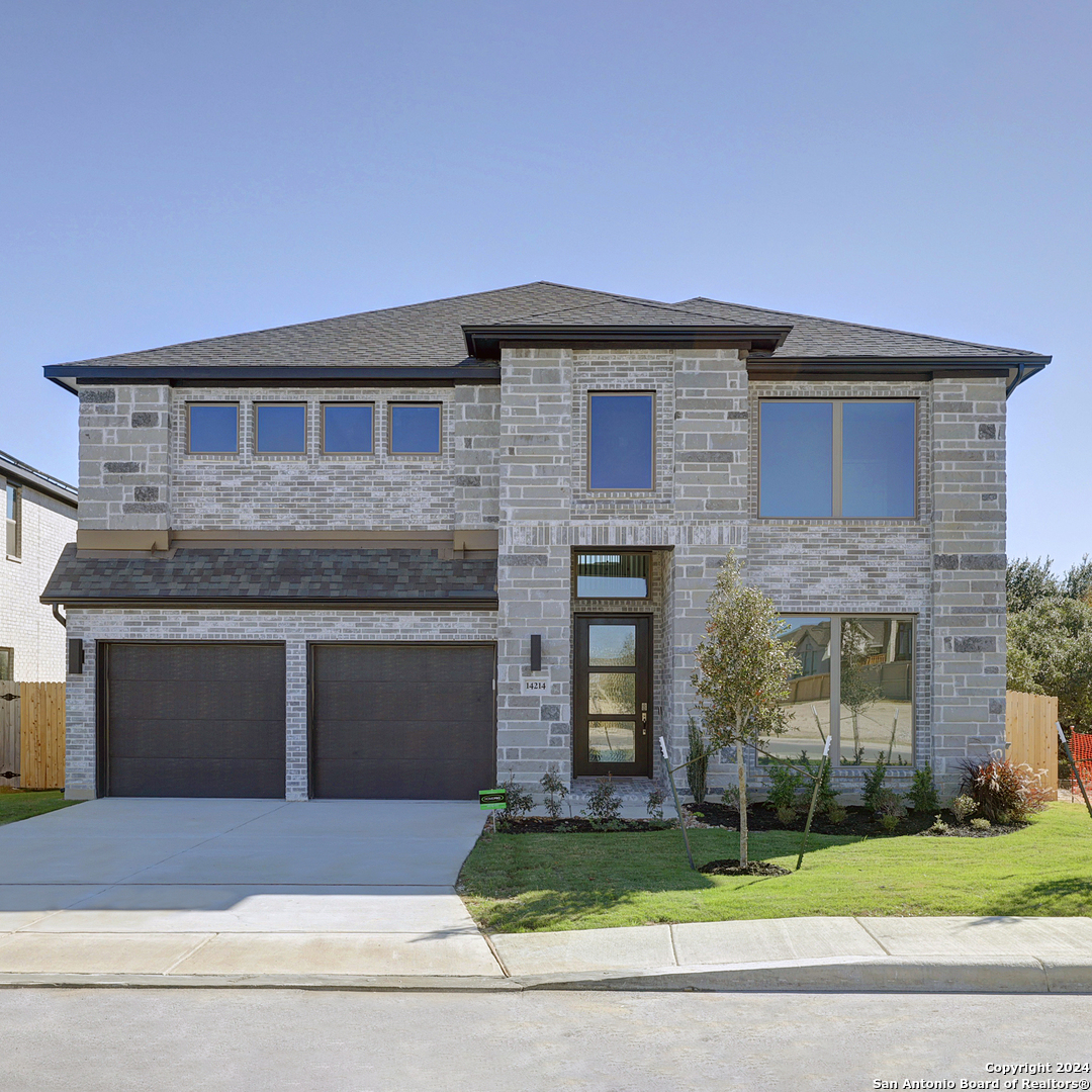 a front view of a house with a yard and garage