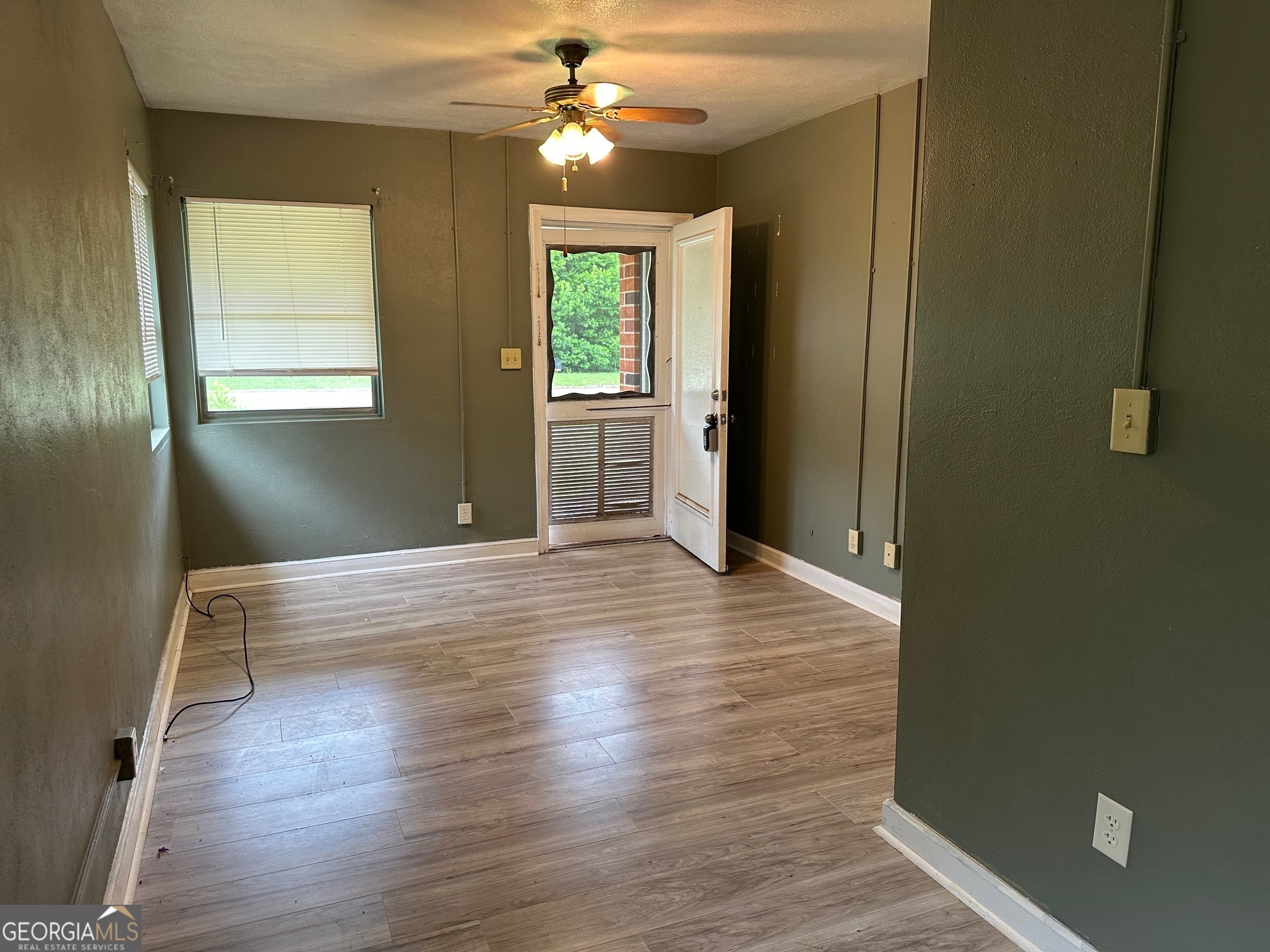 a view of empty room with wooden floor