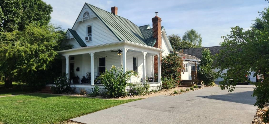 a front view of a house with a garden and plants