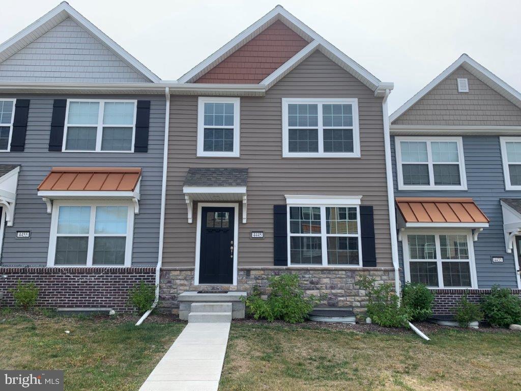 a front view of a house with a yard and outdoor seating