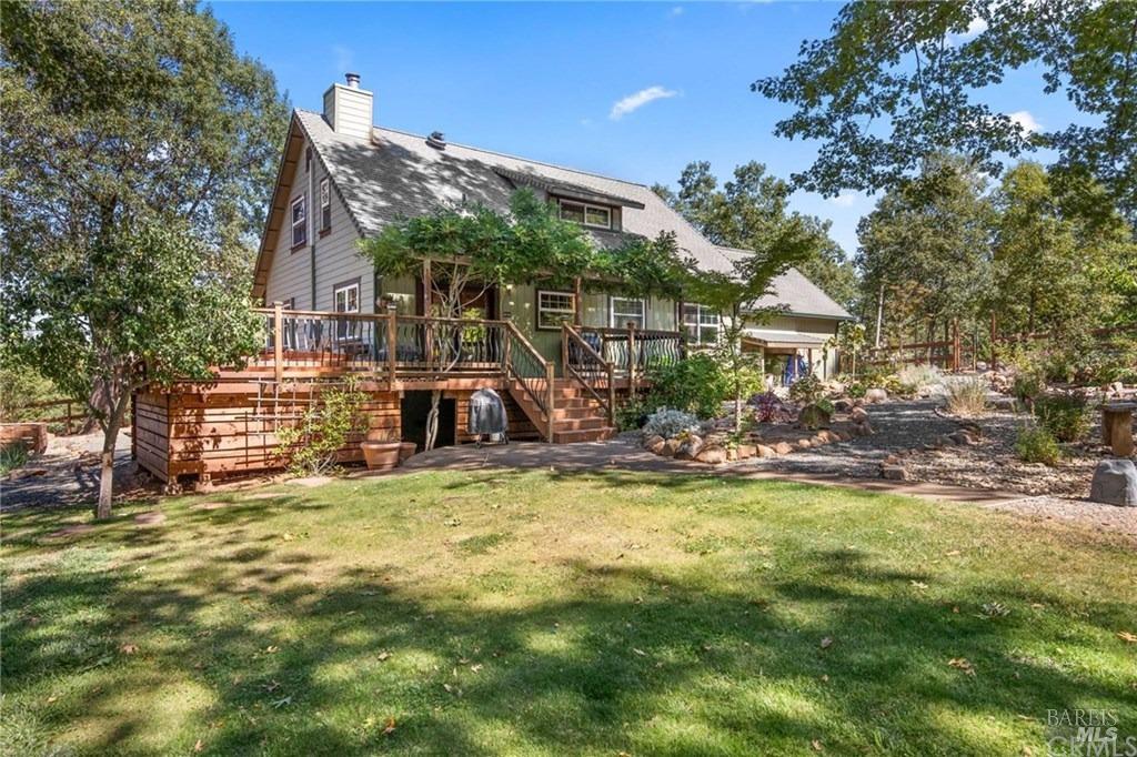 a view of a house with backyard and sitting area