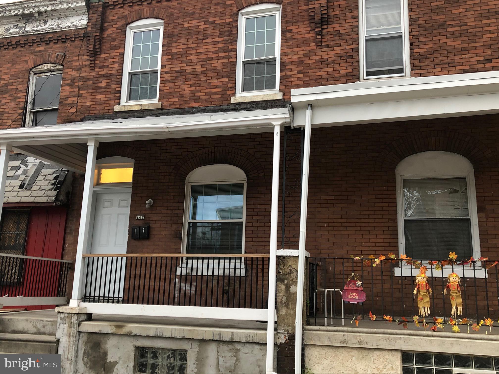 front view of a brick house with large windows