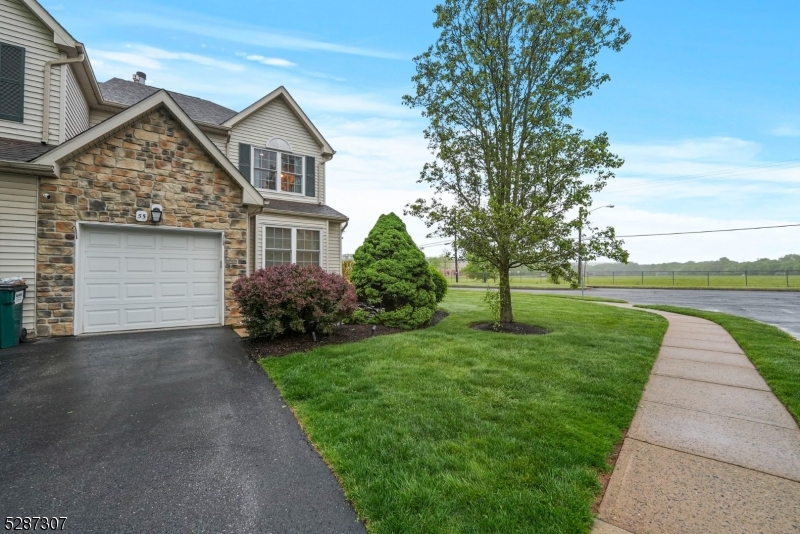 a front view of a house with a yard and trees