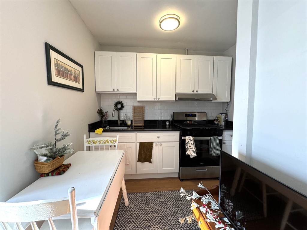 a kitchen with a sink stove and white cabinets