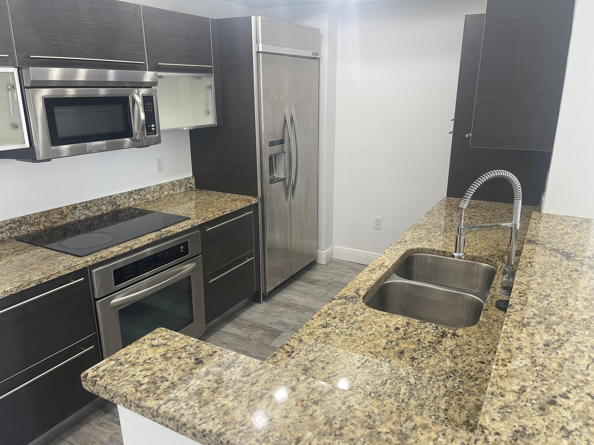 a kitchen with granite countertop a sink and a stove top oven