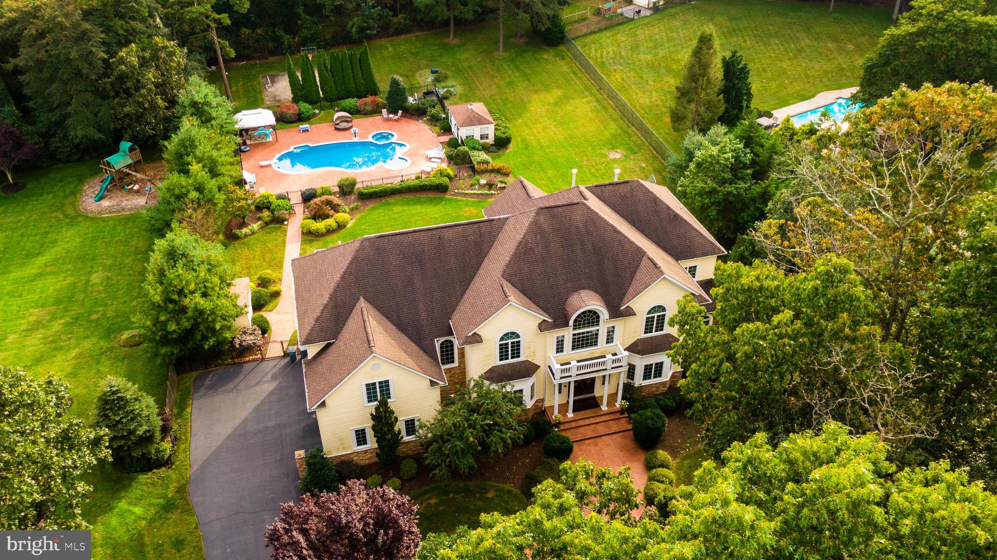 a aerial view of a house with a yard and swimming pool