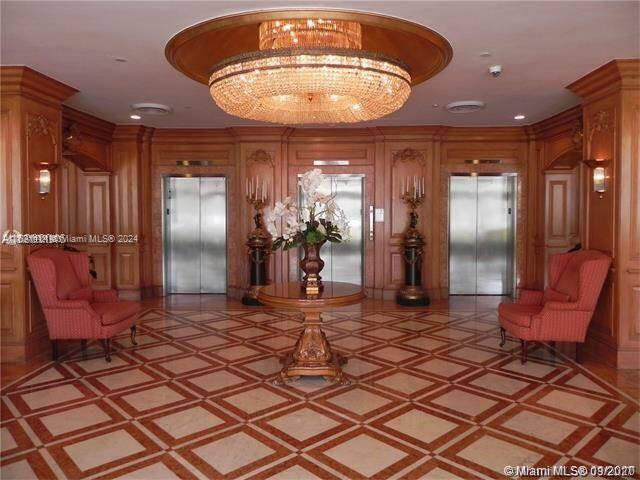 an empty room with a chandelier fan and windows