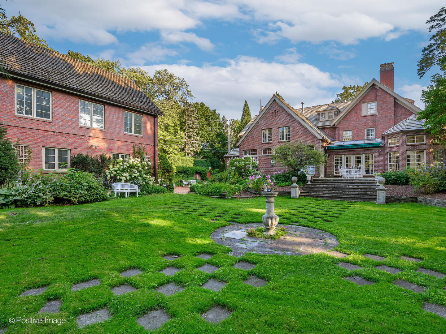 a front view of a house with a yard and garden