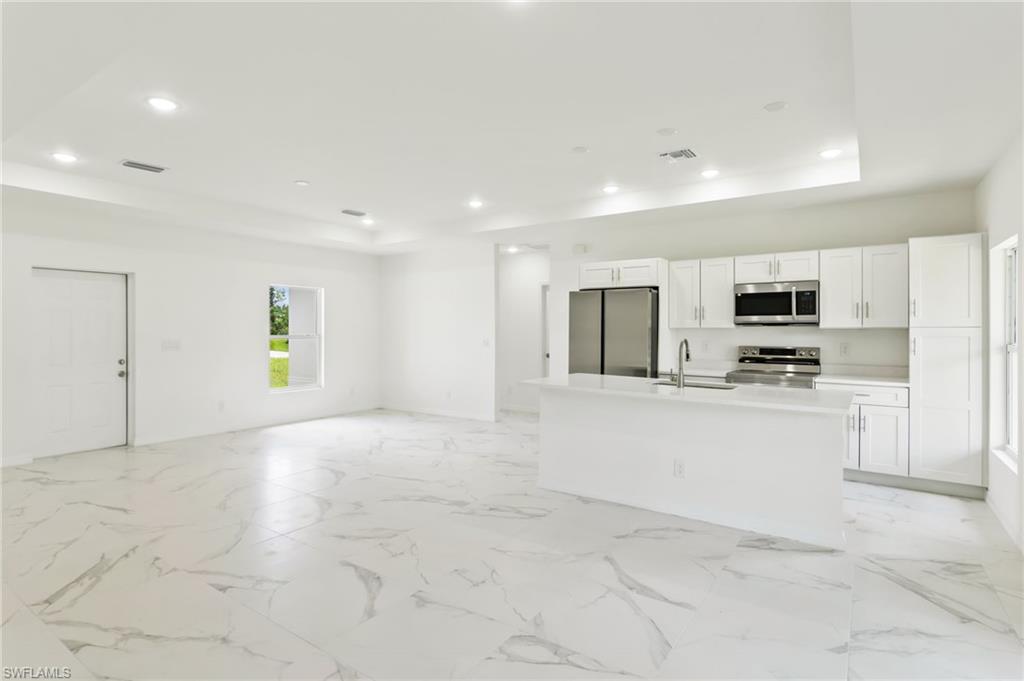 a view of kitchen with stainless steel appliances refrigerator stove microwave and cabinets