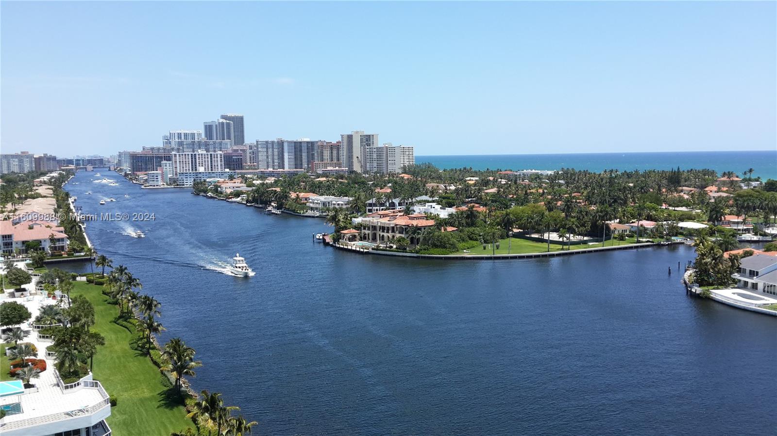 an aerial view of a city with lots of residential buildings ocean and mountain view in back