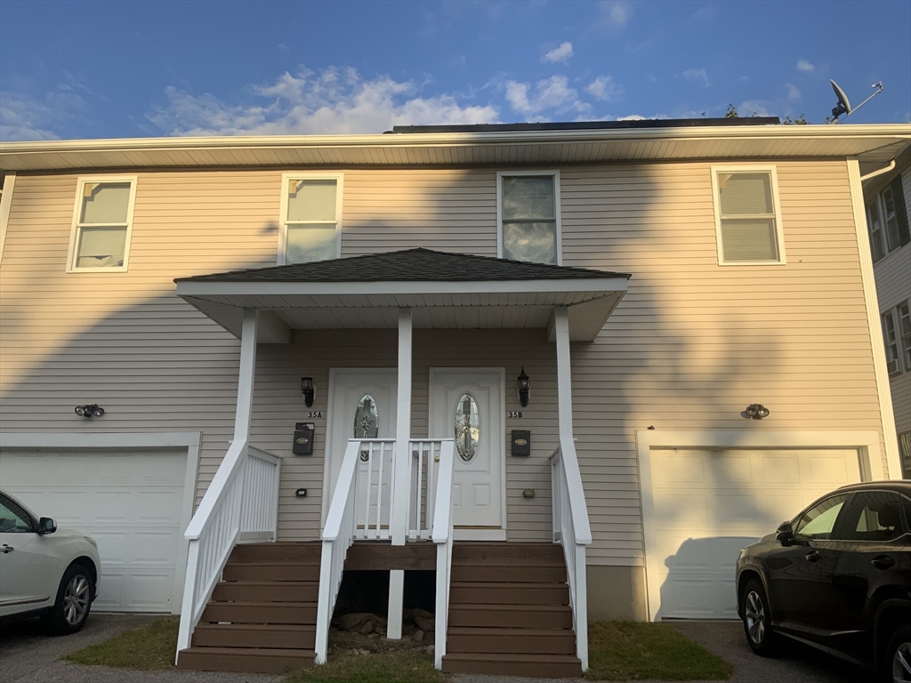 a front view of a house with a car parked