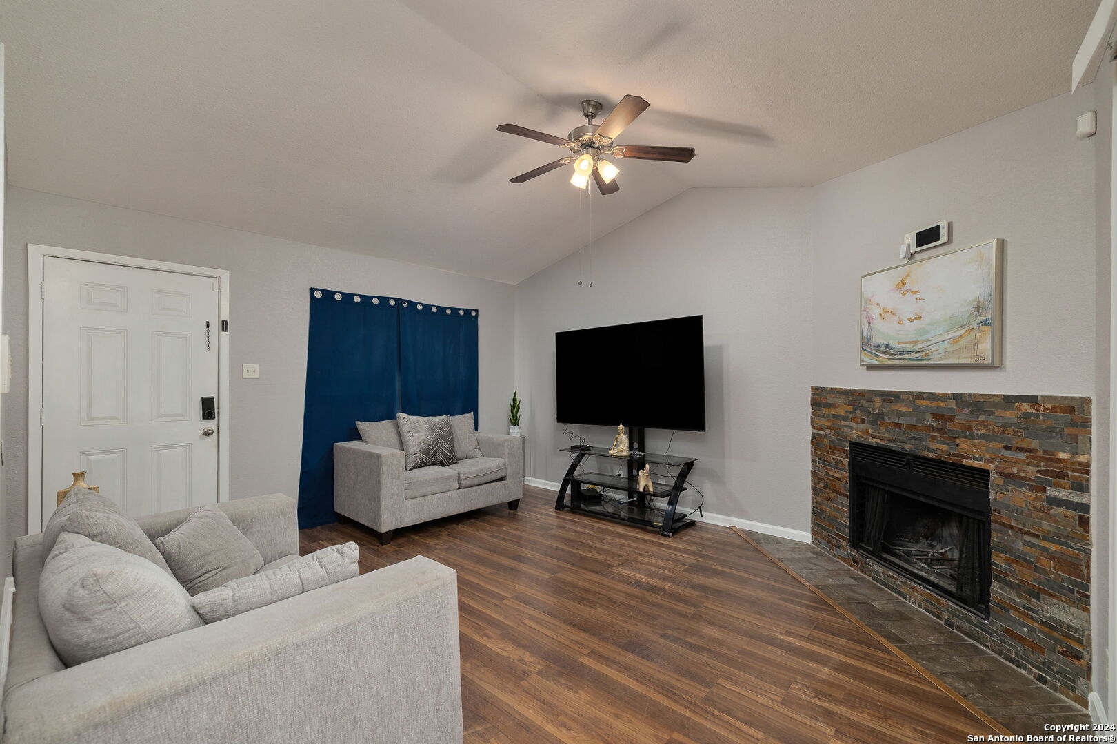 a living room with furniture a flat screen tv and a fireplace