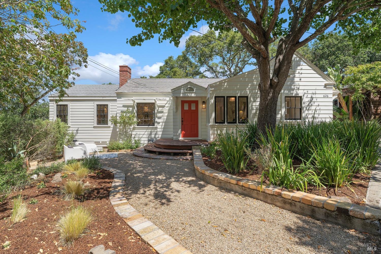 a front view of house with yard and trees around