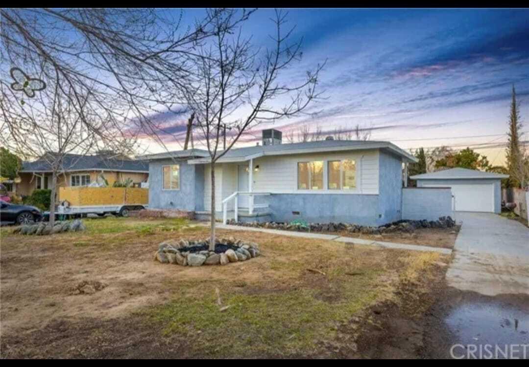 a view of a house with backyard and sitting area