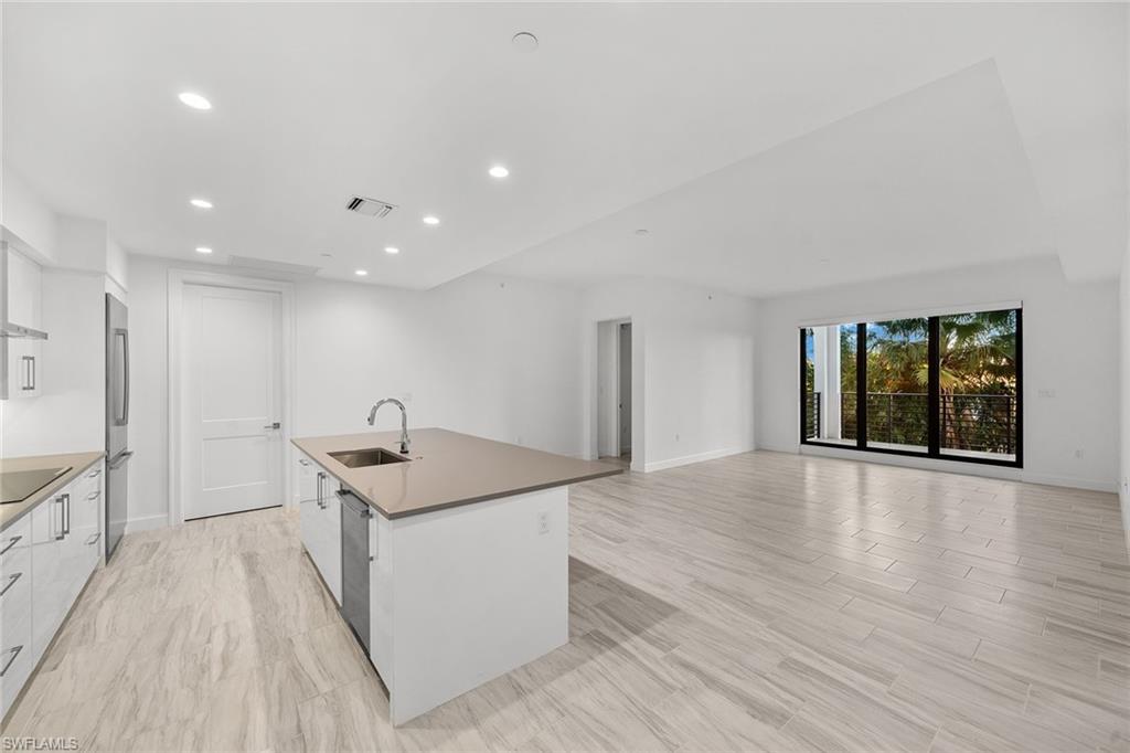 a kitchen with stainless steel appliances granite countertop a sink and a stove top oven