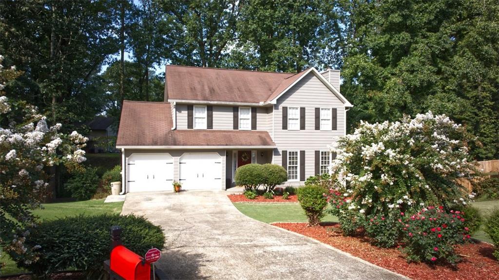 a front view of a house with a yard and trees