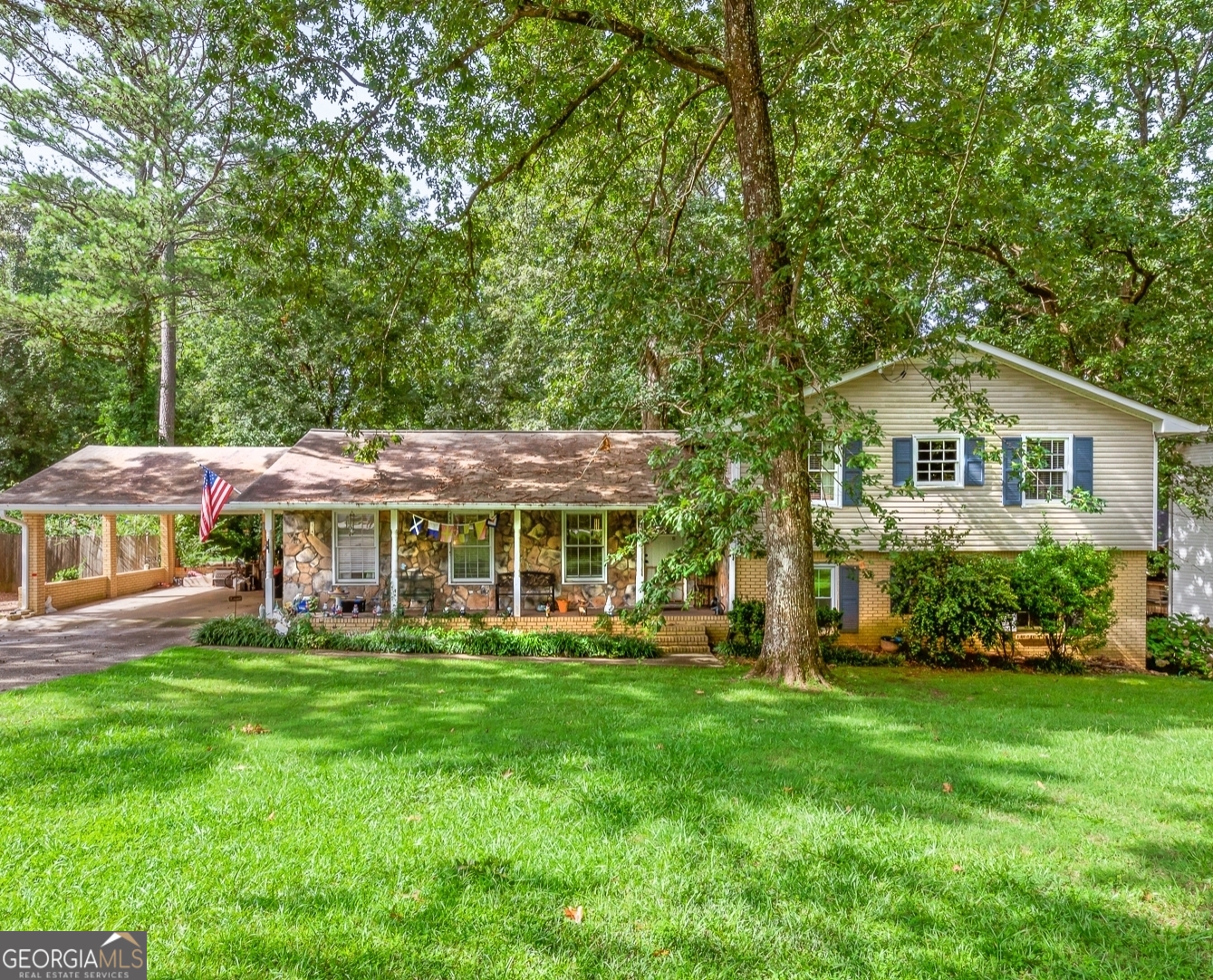 a front view of a house with a garden and trees