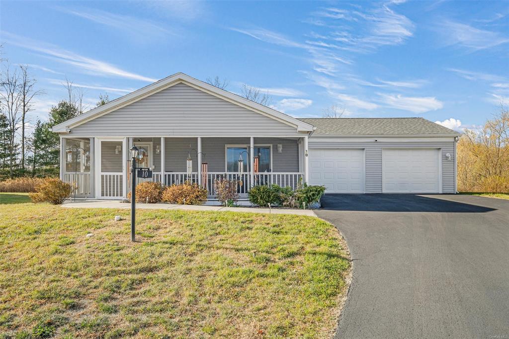 Ranch-style house featuring covered porch, a front yard, and a garage