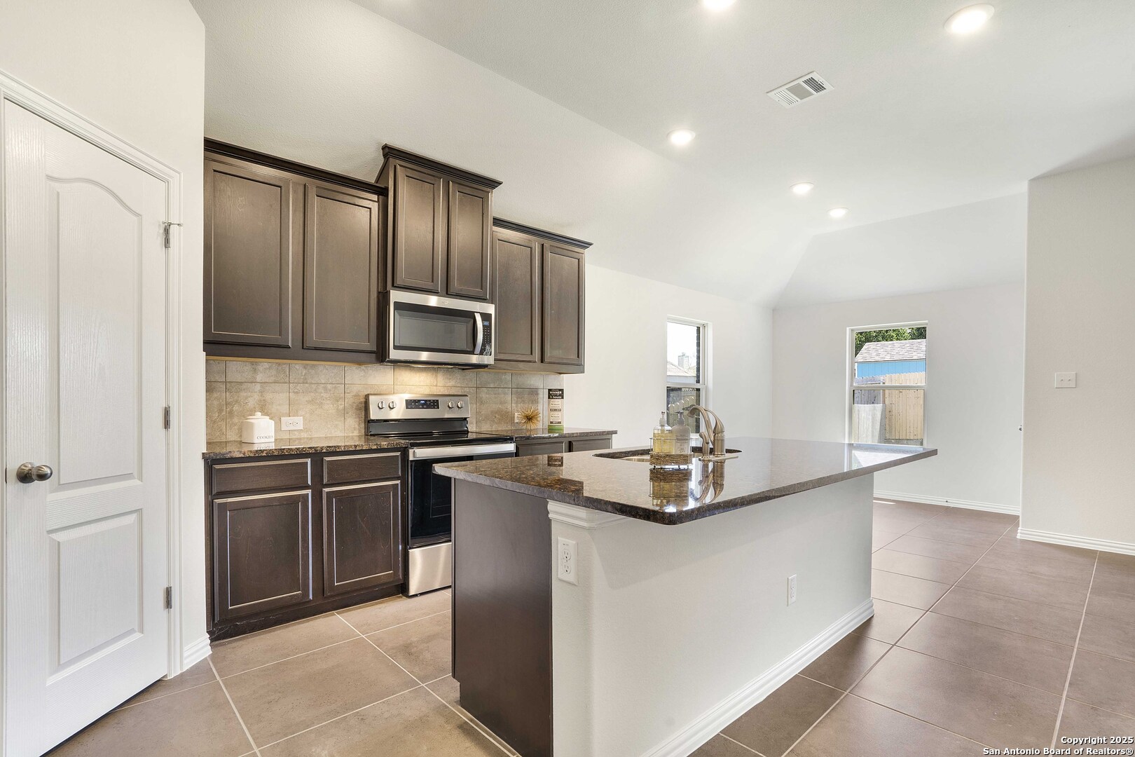 a kitchen with kitchen island granite countertop stainless steel appliances and sink