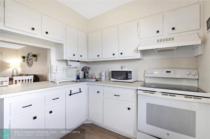 a kitchen with white cabinets and white appliances