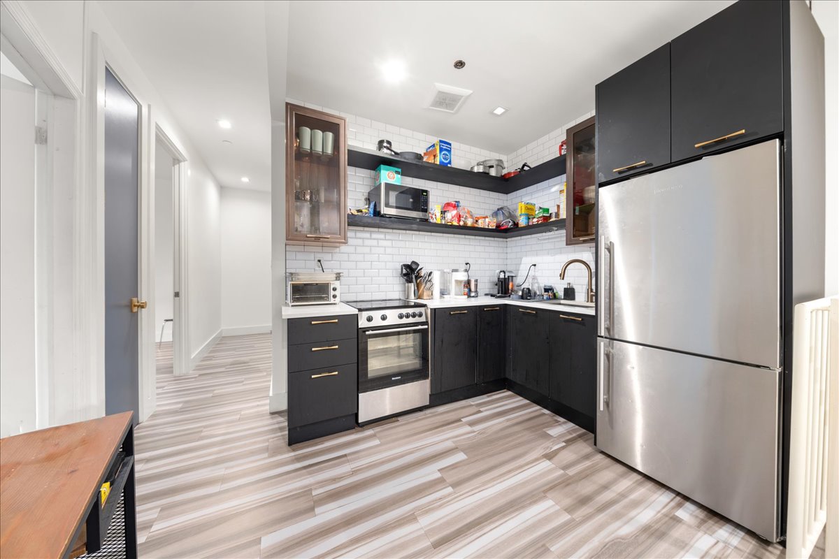 a kitchen with stainless steel appliances granite countertop a refrigerator and a stove top oven