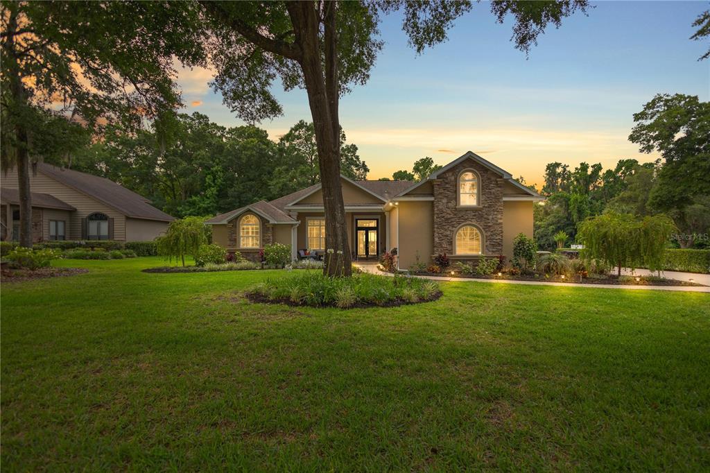 a view of a big house with a big yard and potted plants