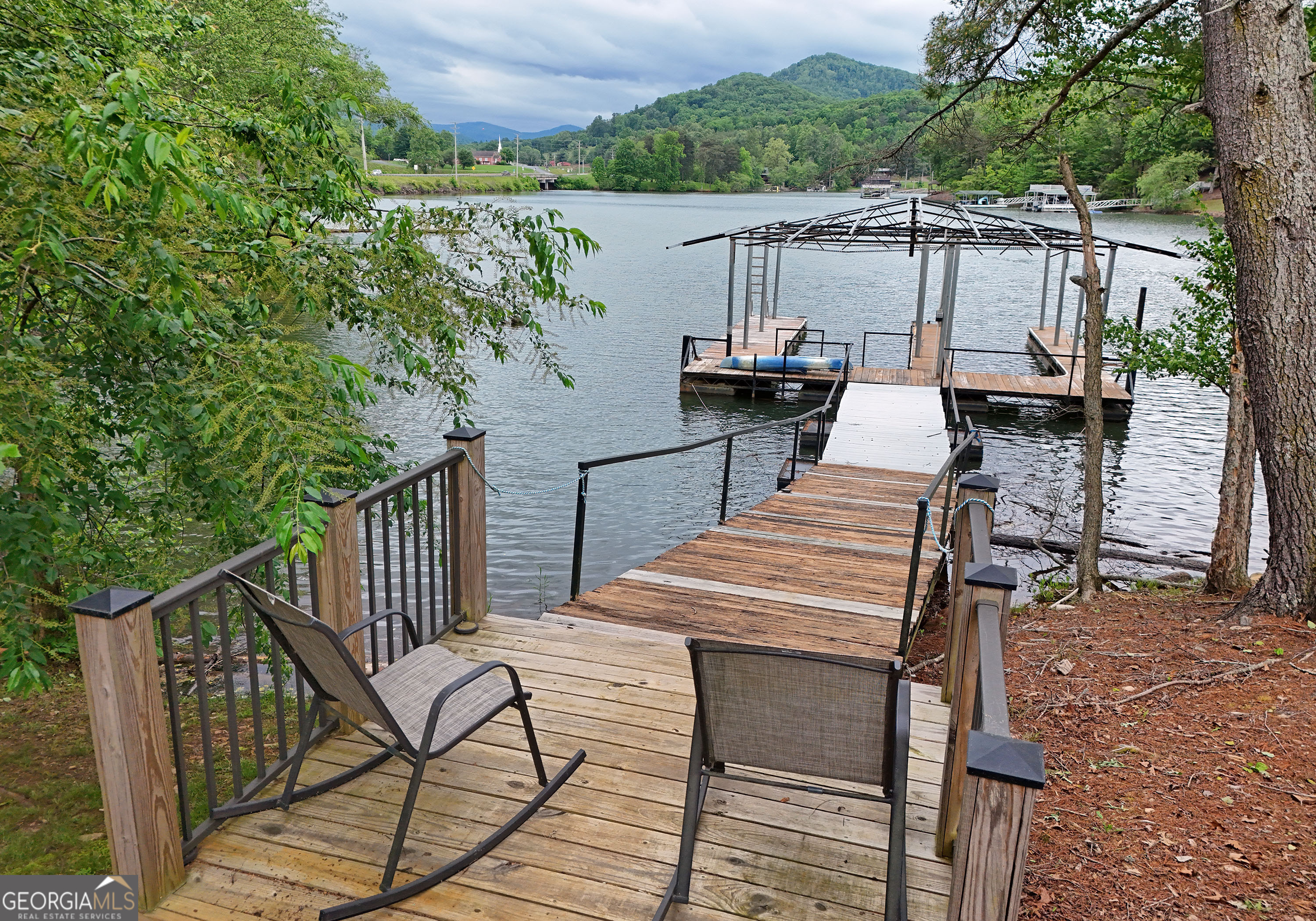 a view of a deck with chairs next to a yard