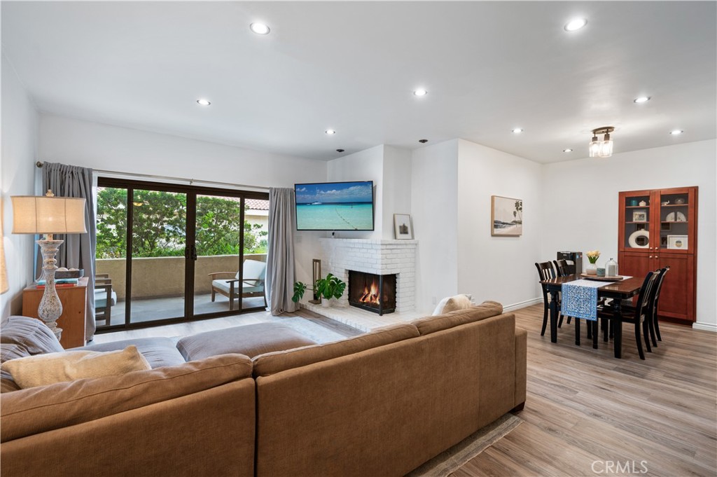 a living room with furniture a fireplace and a floor to ceiling window