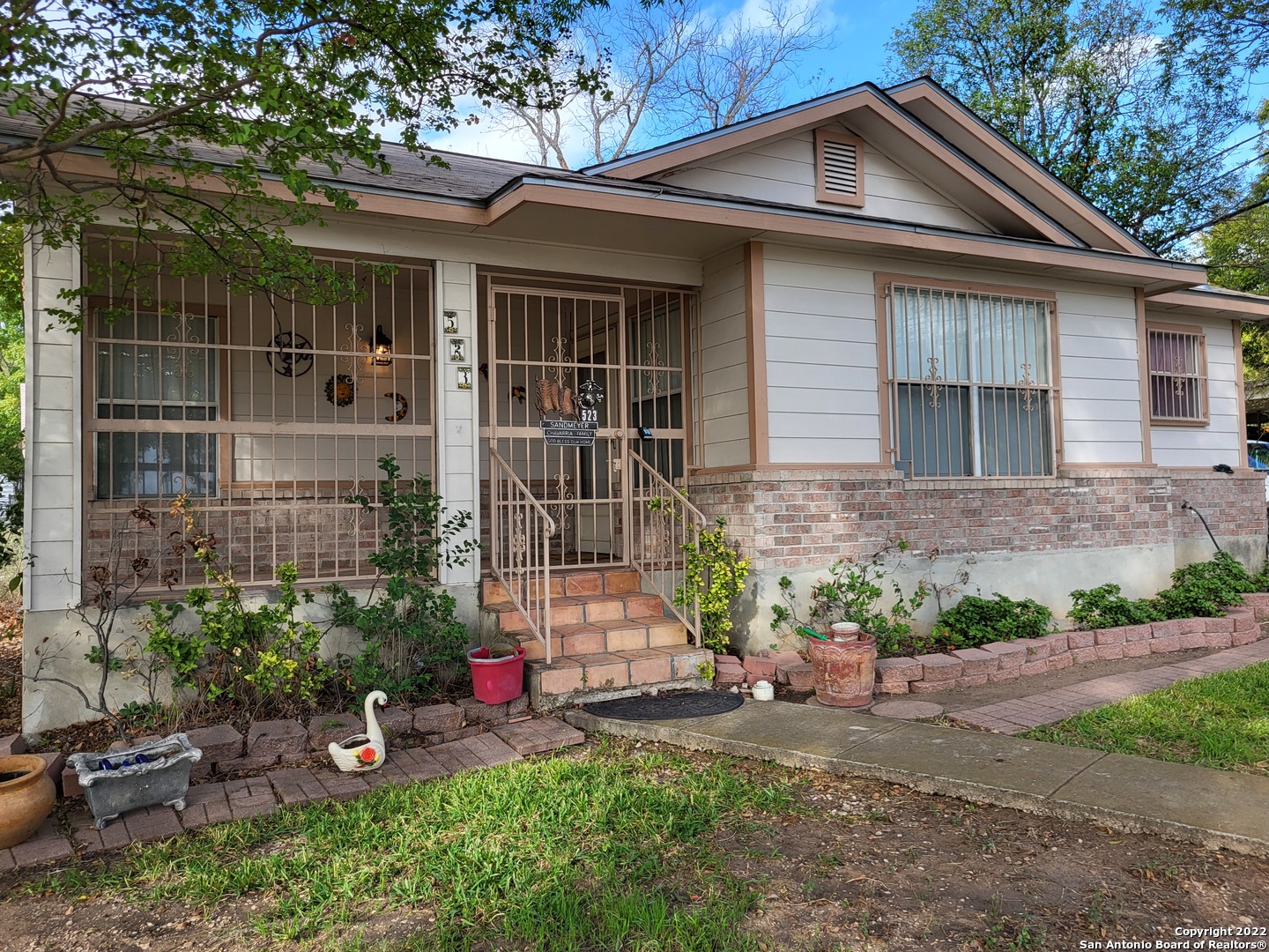 a front view of a house with a yard and potted plants