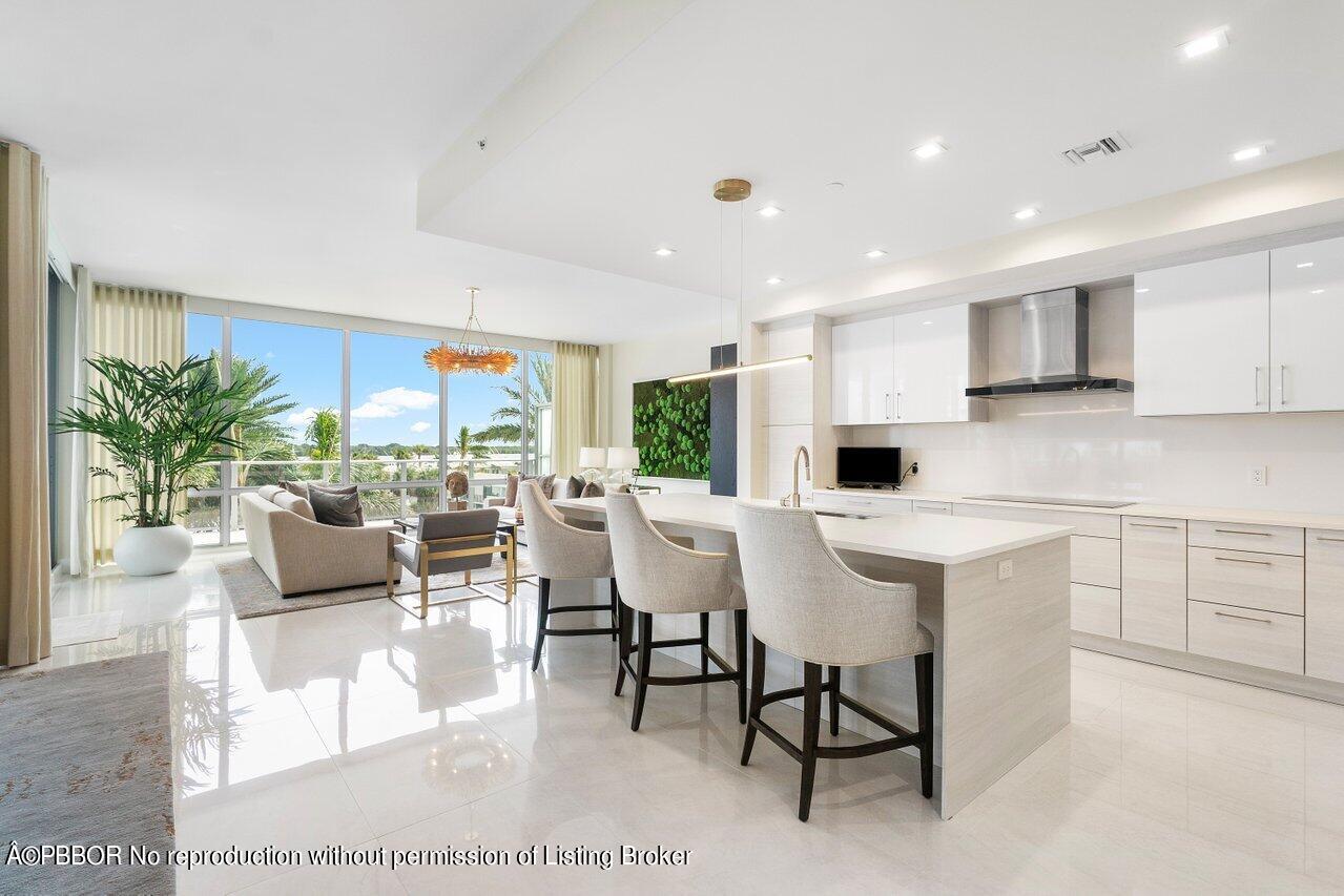 a kitchen with kitchen island granite countertop a table chairs sink and cabinets