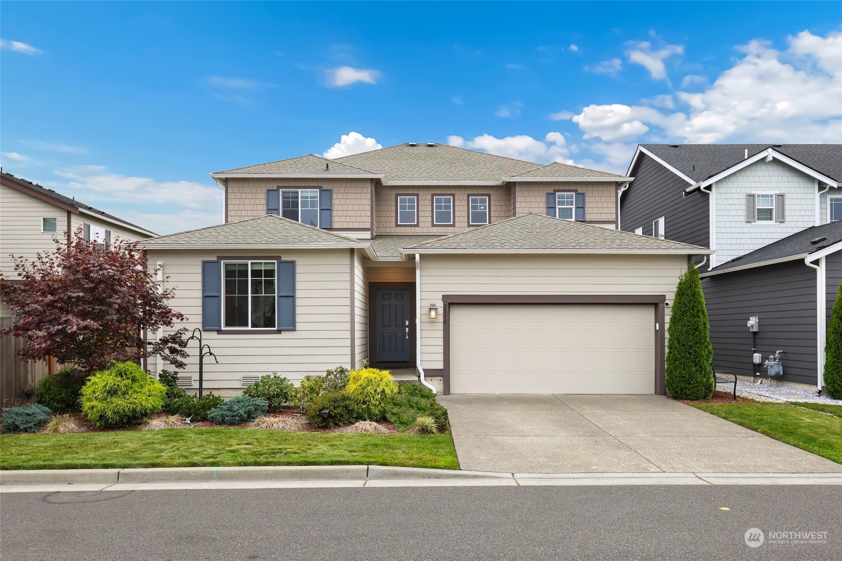 a front view of a house with a garden and garage