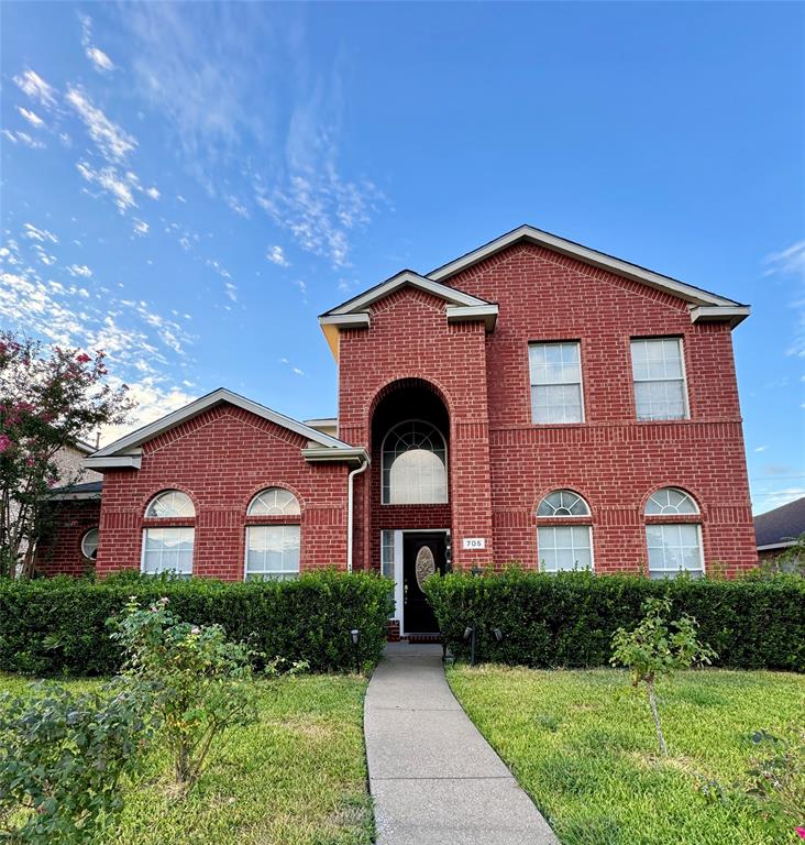 a front view of a house with yard and green space