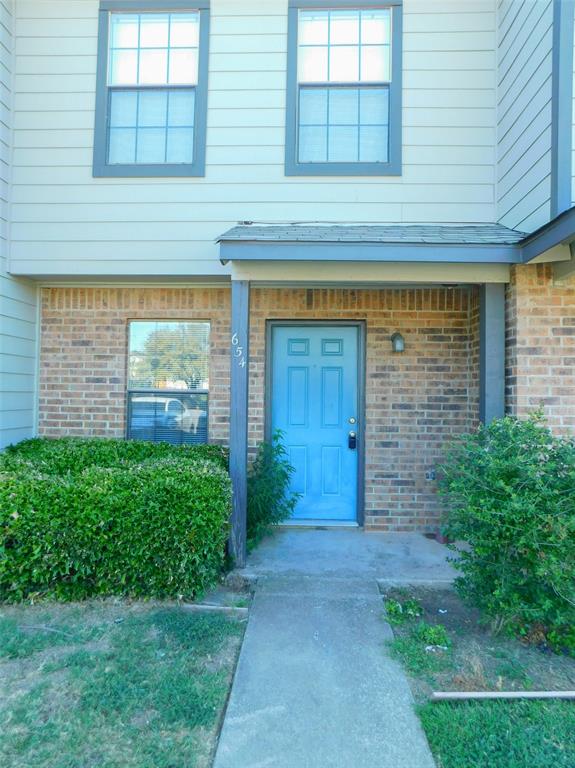 front view of a brick house with a yard