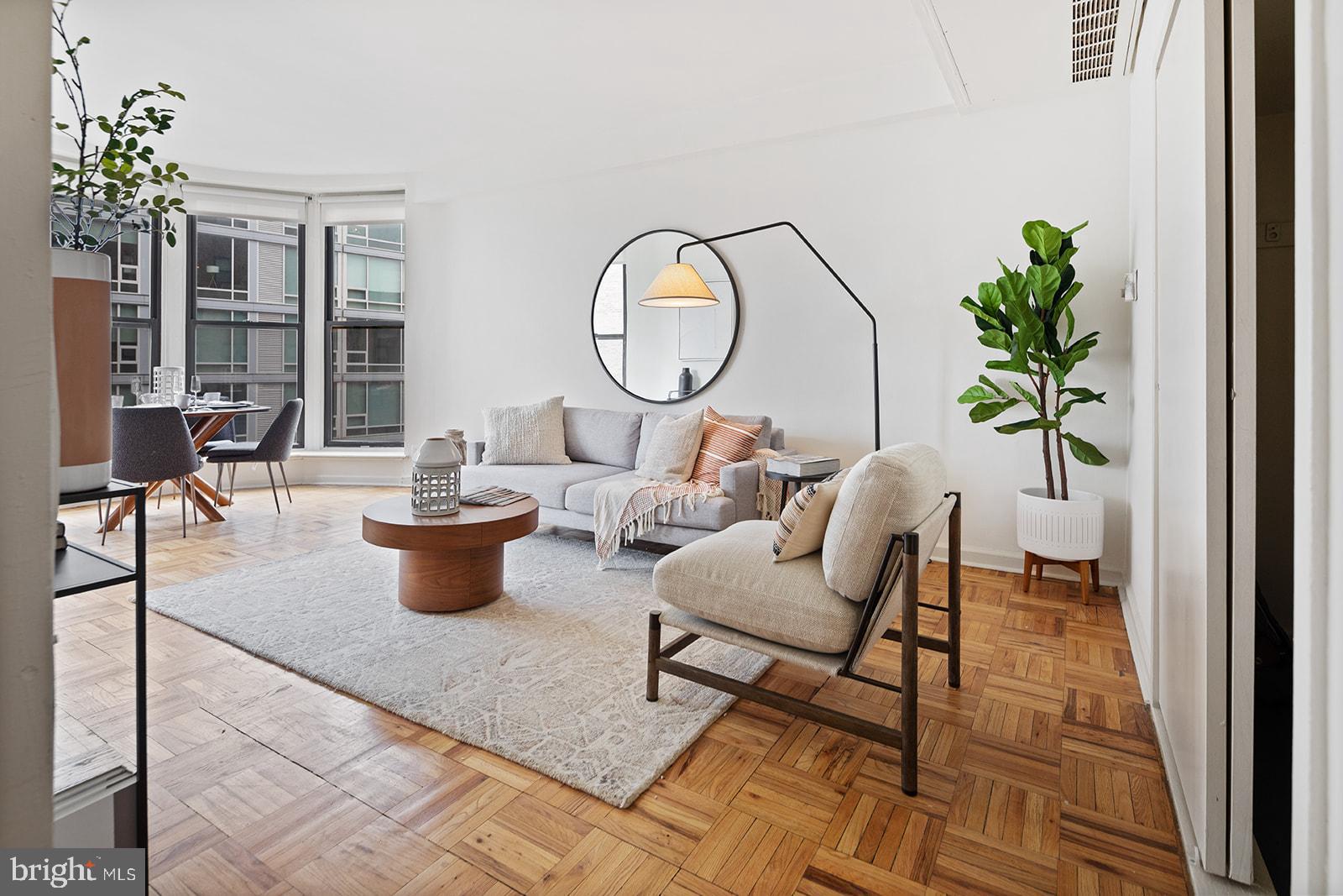 a living room with furniture a window and a potted plant