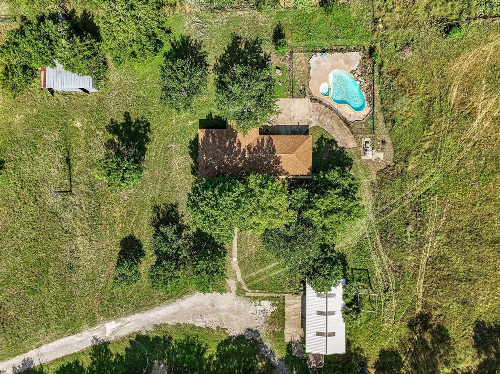 an aerial view of a house with a yard and lake view