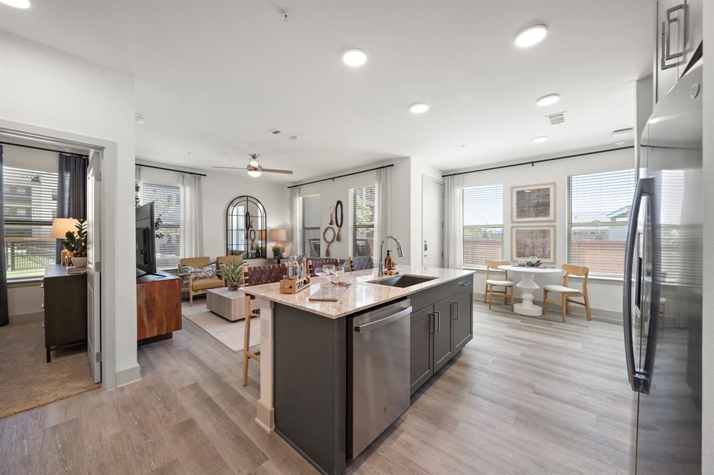 a large kitchen with stainless steel appliances a lot of counter space and a wooden floor