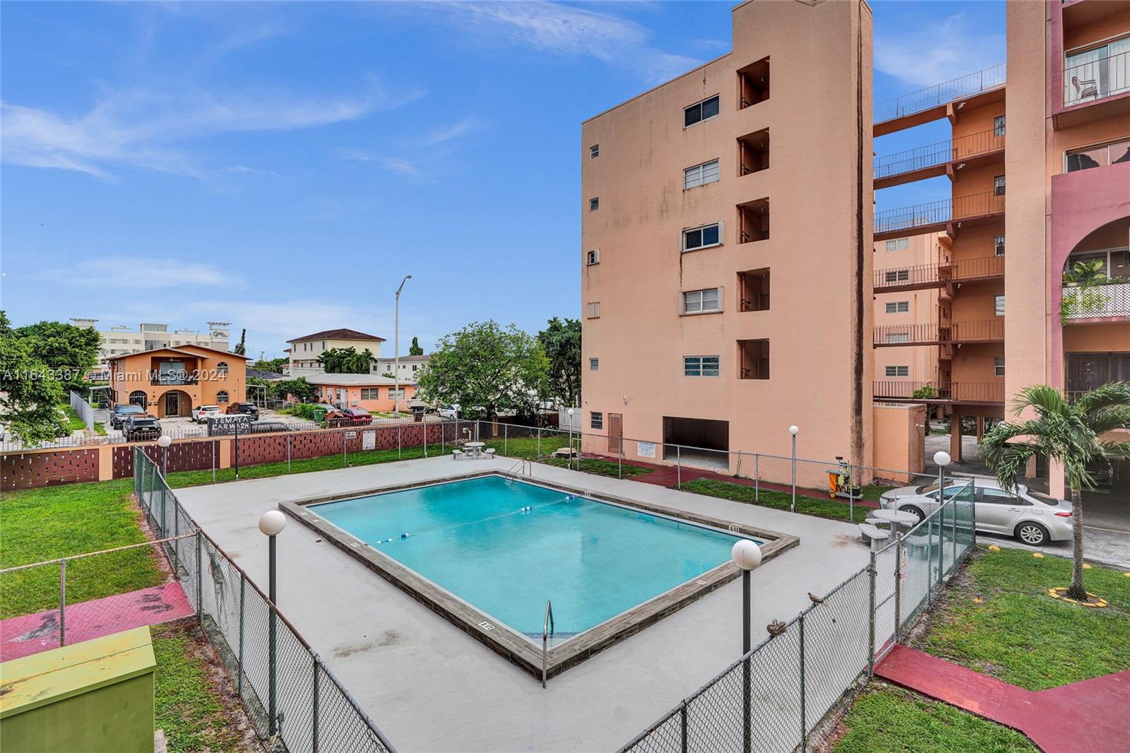 a view of a swimming pool with lawn chairs and a yard